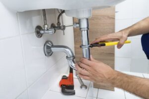 A man takes apart a drain.