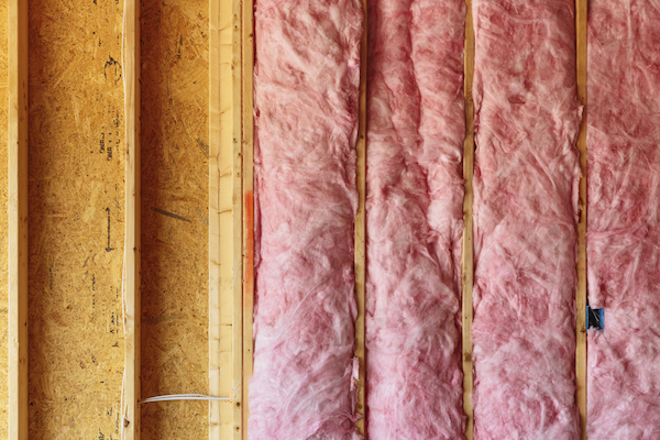 pink insulation in unfinished wall of plywood