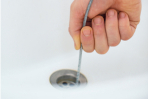 threading a plumber's snake into a drain