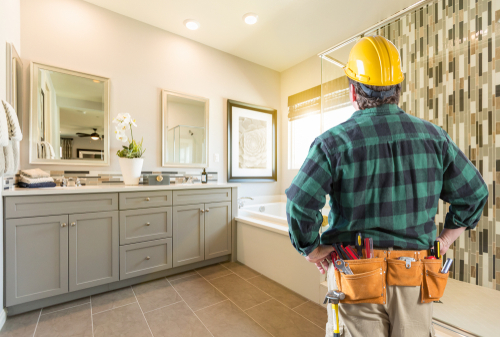 A plumber surveys a bathroom after a remodel projects.