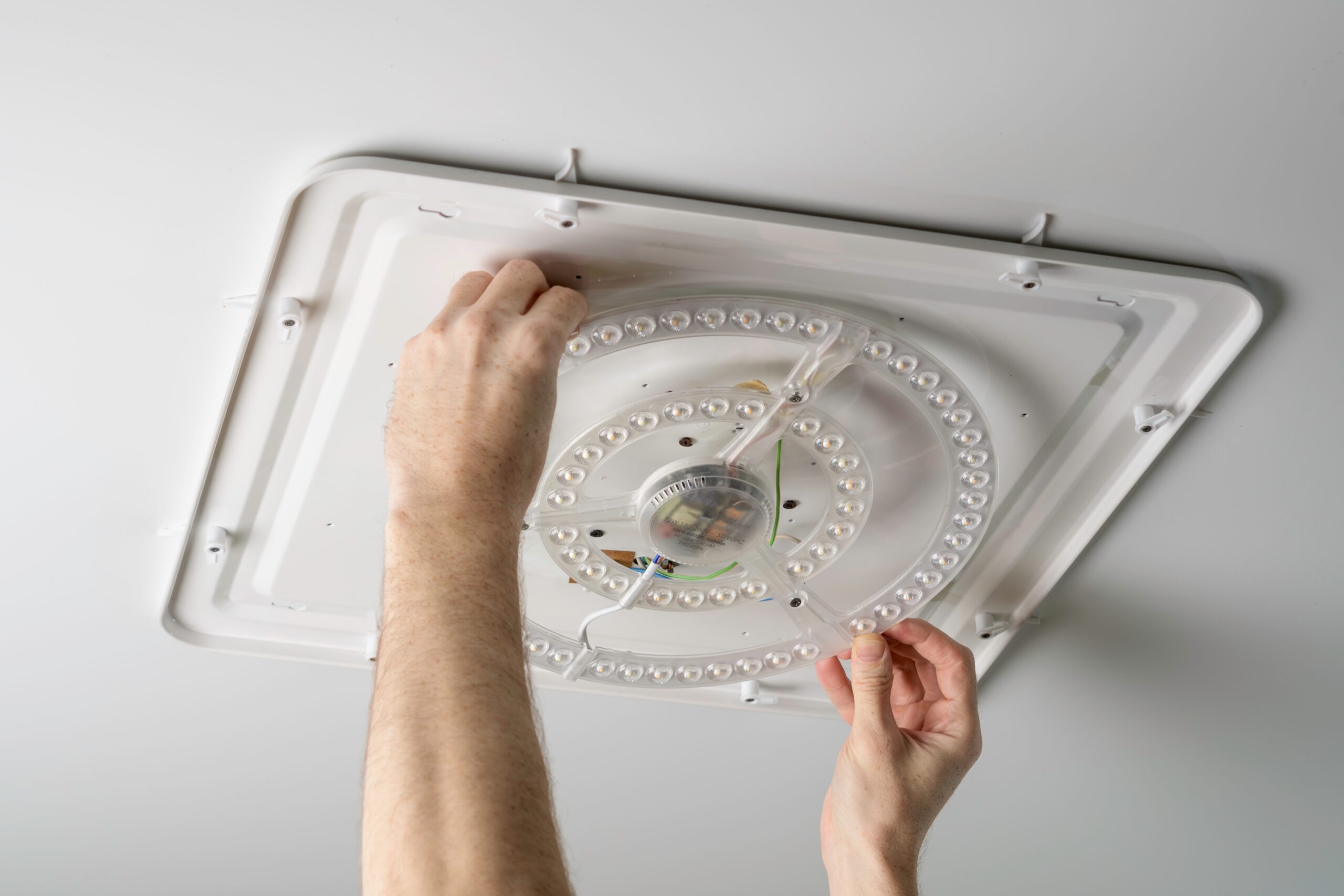 electrician performing light fixture repair that keeps your home safe and well-lit